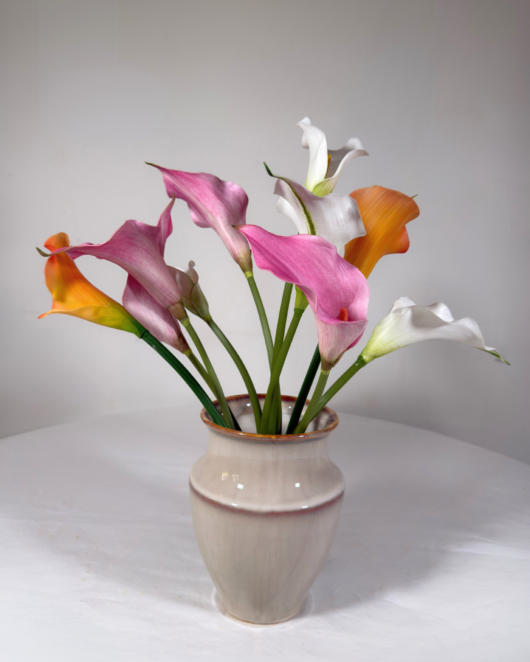 The Chelsea silk flower arrangement — clean structured real-touch stems in a clear glass vase. Made to order in NYC.