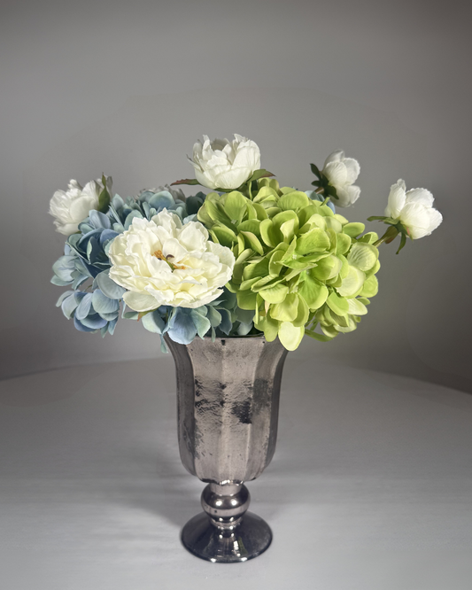 The Dakota silk hydrangea arrangement — three blue-and-green faux hydrangea stems with a single ivory peony in a clear glass vase. 11 inches tall. Hand-arranged in NYC by Deadass Flowers.