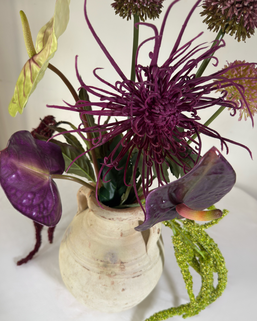 Side view of The Delancey Large silk flower arrangement showing trailing amaranthus stems.