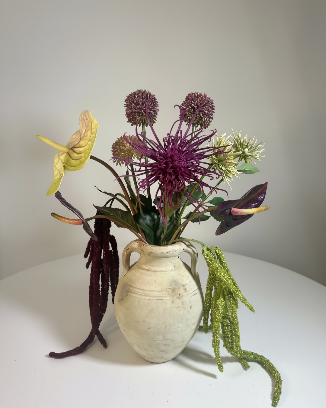 The Delancey Large — dark moody silk flower arrangement with purple anthurium, allium spheres, and trailing chartreuse amaranthus in a ceramic vessel. Made to order in NYC.