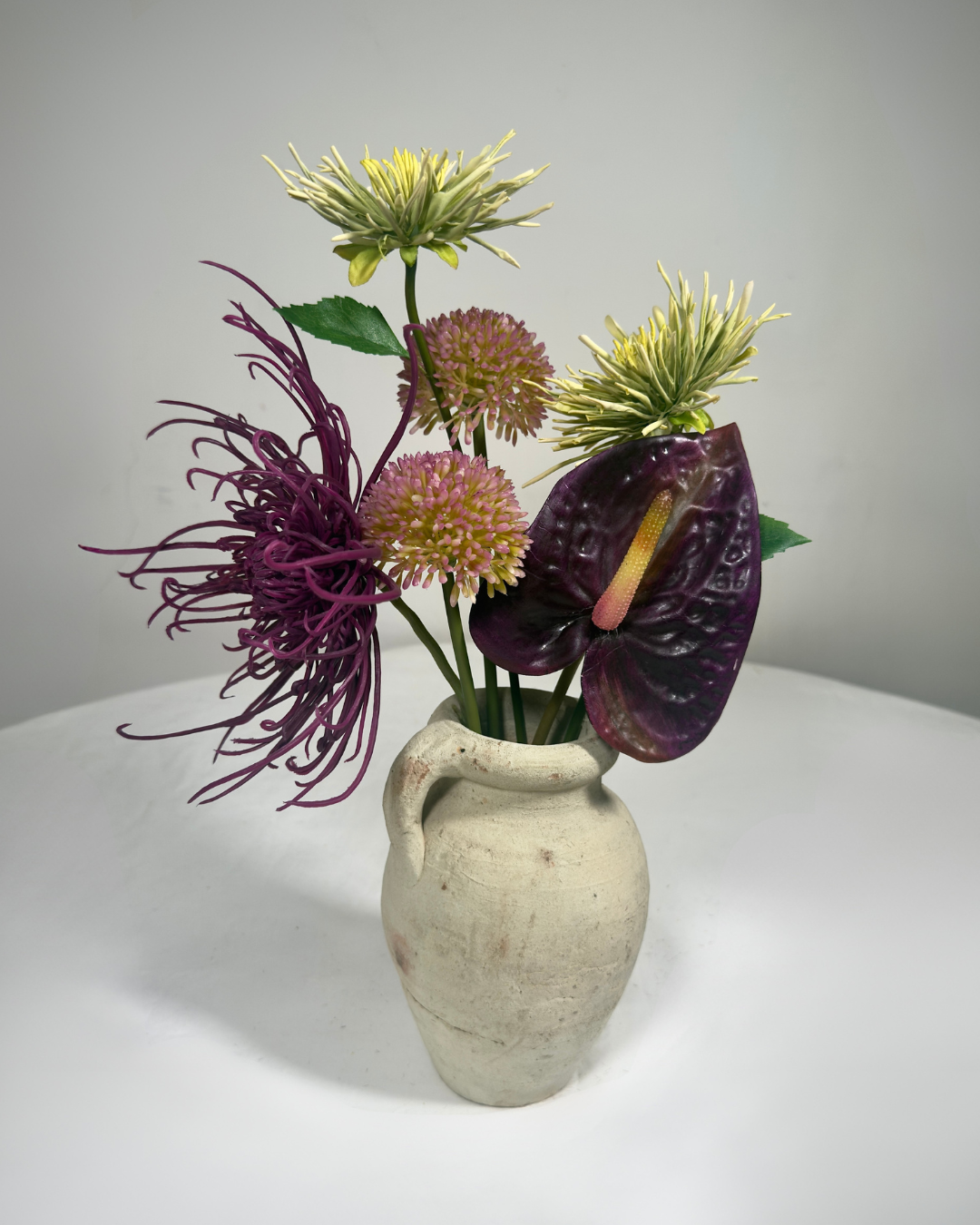 The Delancey Mini — compact dark silk flower arrangement with purple anthurium and amaranthus, NYC made-to-order.