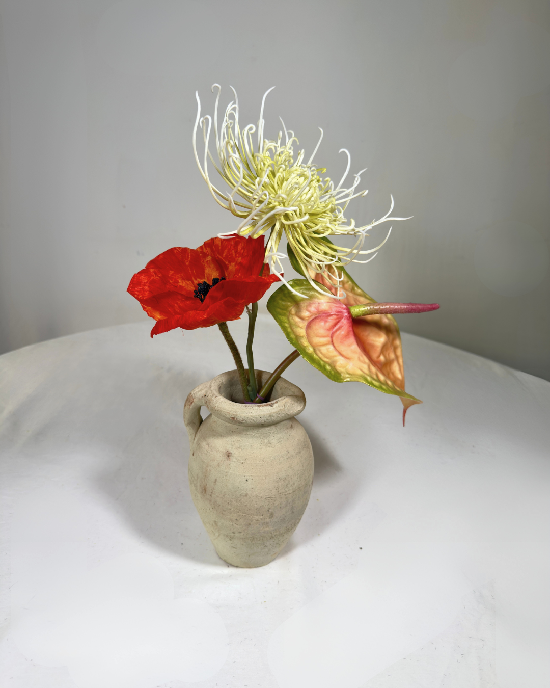 Henry St Mini — compact warm copper silk flower arrangement with real-touch red poppy, anthurium, and spider mum in a ceramic vessel. Made to order in NYC.