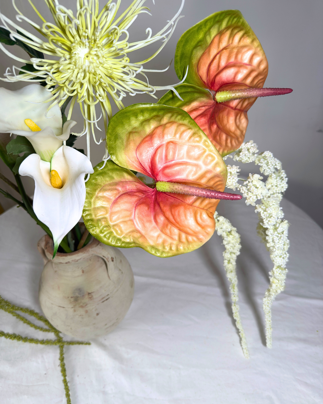 Close-up detail of The Henry St Large — real-touch anthurium, white calla lily, and spider mum in warm copper tones with trailing amaranthus. Silk flowers handmade in NYC.