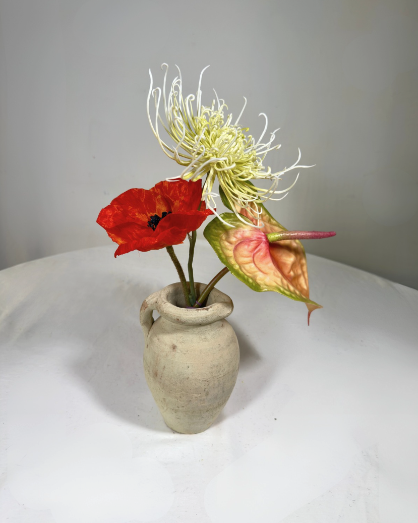 Small terracotta bud vase shown from a second angle, neutral handmade finish.