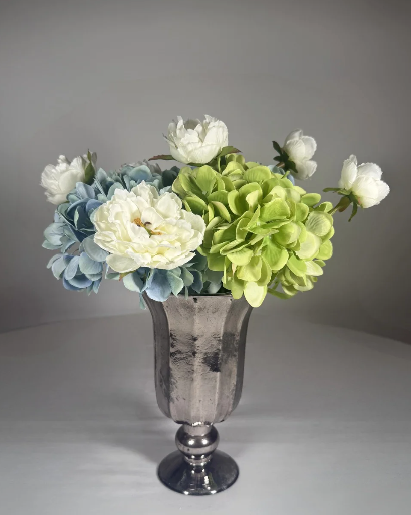 Tall silver urn vessel shown from a second angle, narrow neck and silver finish.